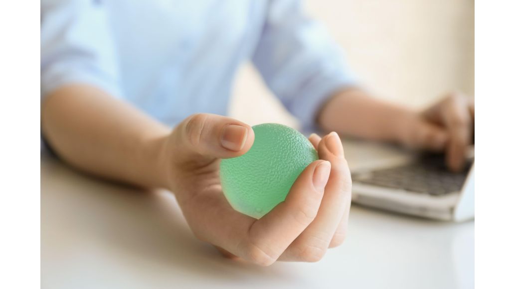 person squeezing ball when on computer